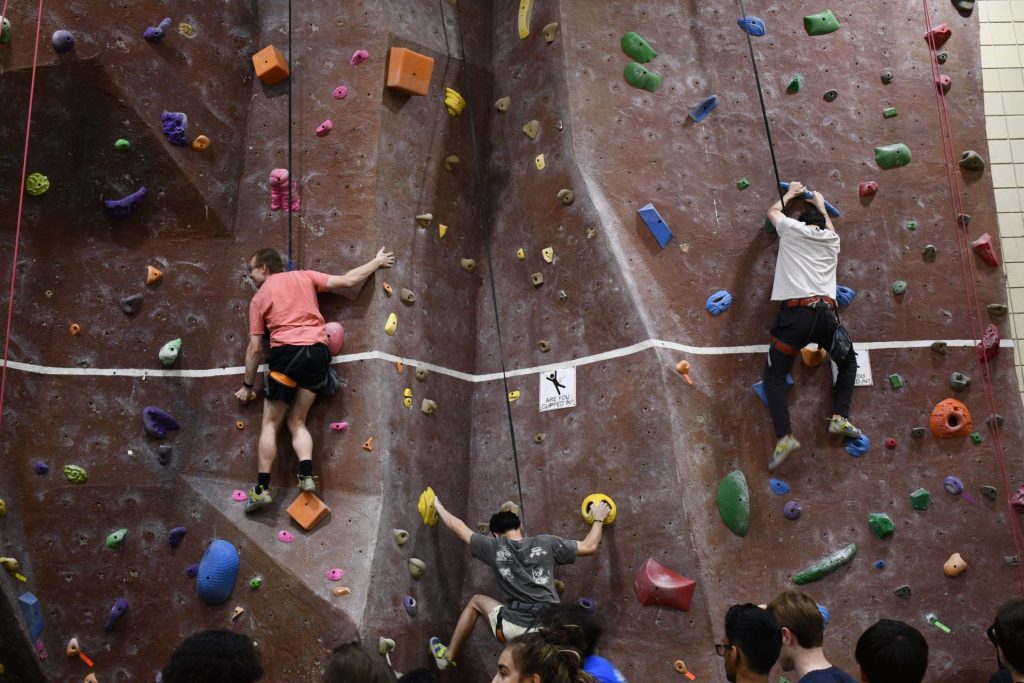 People ascending the climbing wall.